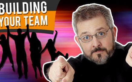 dave curlee enthusiastically pointing forward toward you. White text reads Building Your Team on top of black and orange background with a silhouette of people jumping up in the air happily
